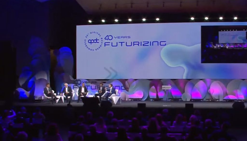 Conferência com painel de discussão em evento corporativo.